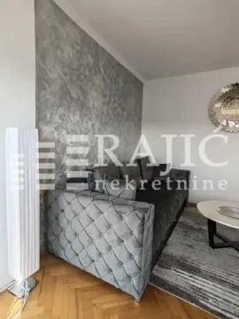 Furnished living room with a corner sofa and a decorative wall. - image 5