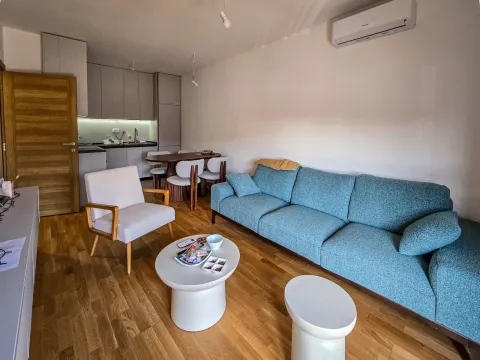 Dnevna soba sa garniturom, stočićima i pogledom na kuhinju sa trpezarijom. - image 11