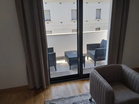 View from the room onto the furnished balcony with seating set. - image 3