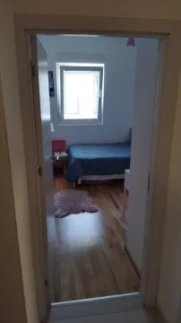 Spavaća soba sa krevetom viđena kroz otvorena vrata. - image 6