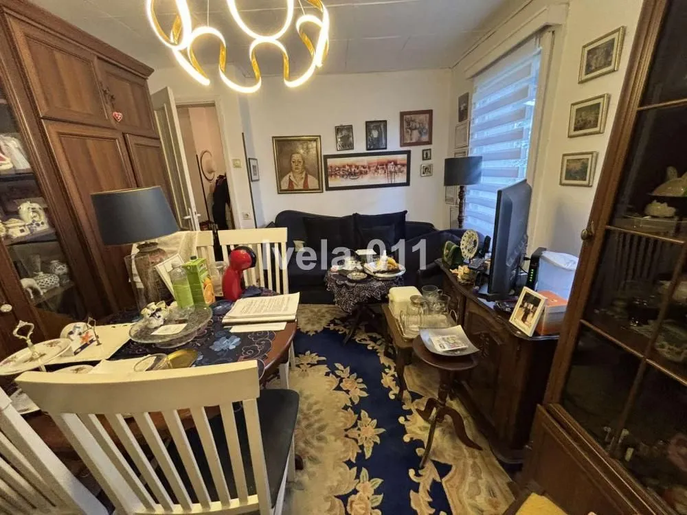 Living room with a dining table, sofa set, and traditional furniture.