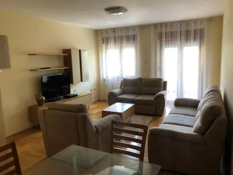Prostrana dnevna soba sa garniturom za sjedenje i televizorom. - image 3