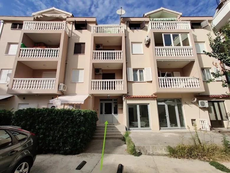 Front view of the apartment building with balconies and ground floor entrance.