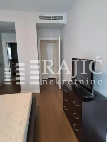 View of the bedroom with a bed and a dresser with a TV.