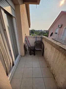 Manji popločani balkon sa stolicama i pogledom na okolne kuće. - image 8