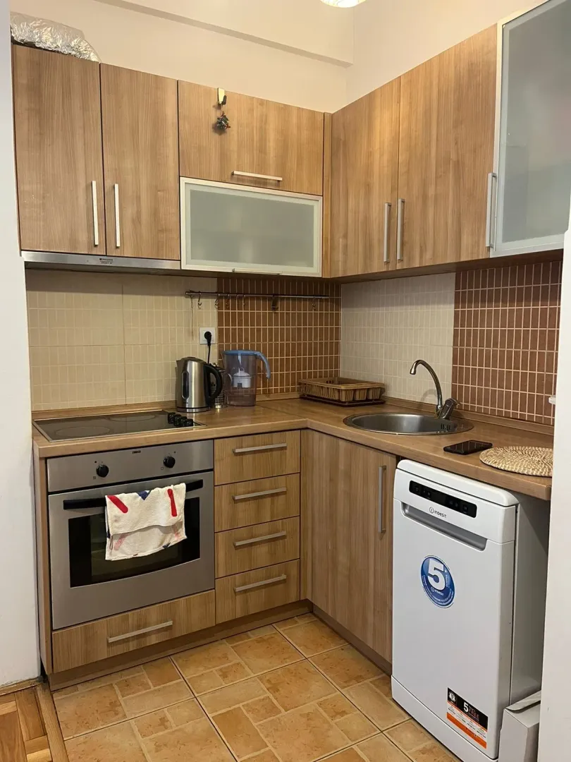 Kitchen with wooden cabinetry, built-in oven, and dishwasher.