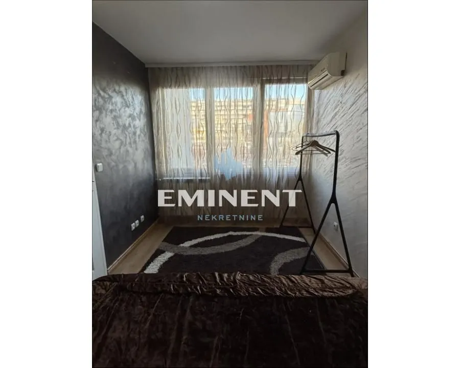 Smaller bedroom with a bed, air conditioning, and a large window.