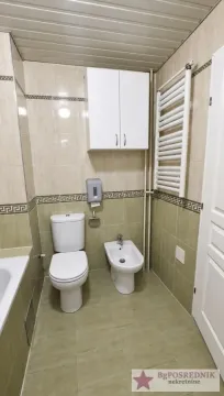 Bathroom equipped with a toilet, bidet, wall cabinet, and radiator. - image 13