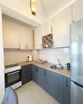 Small kitchen with two-tone cabinetry, a stove, and a refrigerator. - image 10
