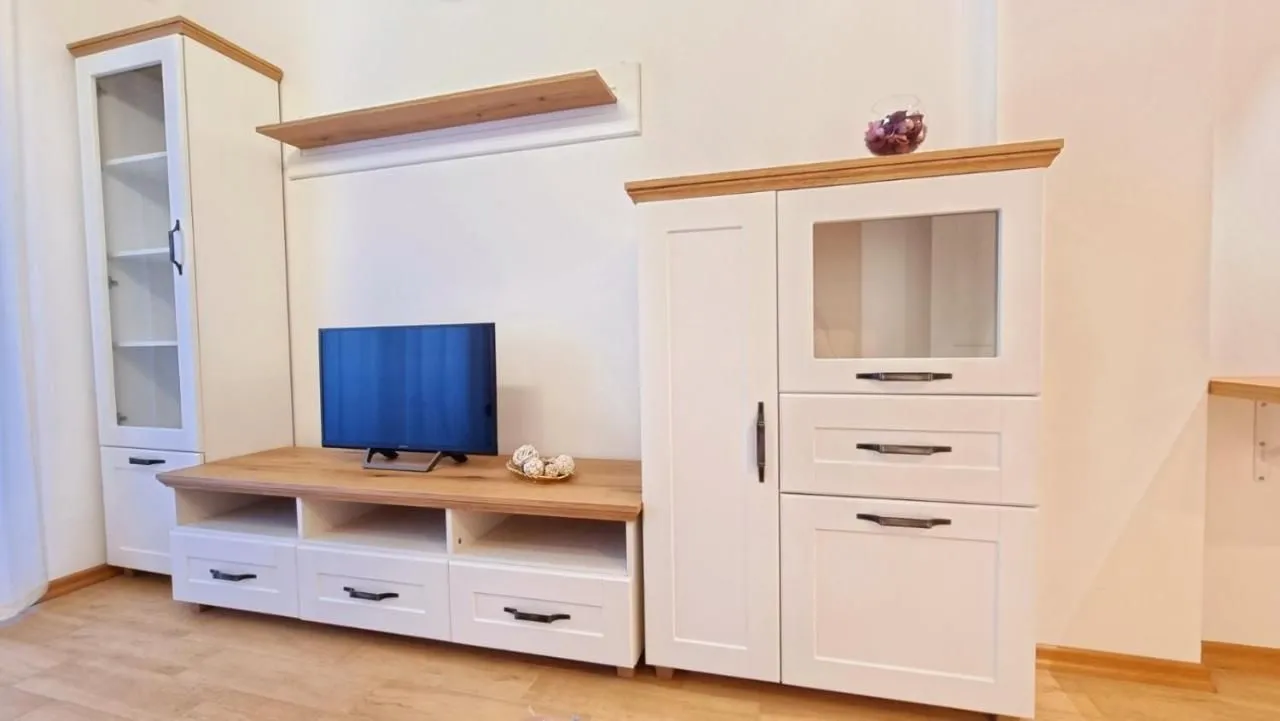 Living room with white furniture unit and a television.