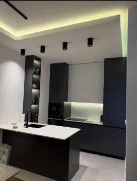 Modern kitchen with dark elements and an island. - image 3