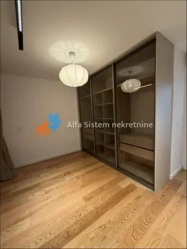 Spavaća soba sa ugradnim ormanom sa staklenim kliznim vratima i drvenim podom. - image 14