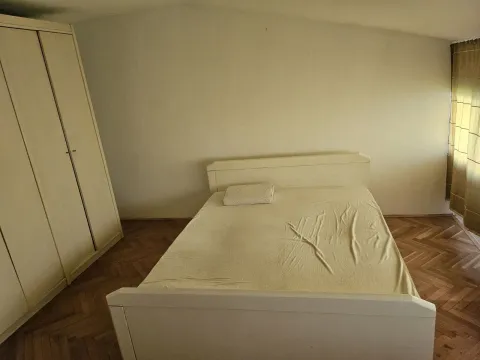 Jednostavno namještena spavaća soba sa bračnim krevetom i velikim ormarom. - image 4