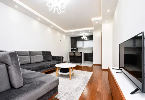 Spacious living room connected to the kitchen, featuring a sofa and TV cabinet. - image 2