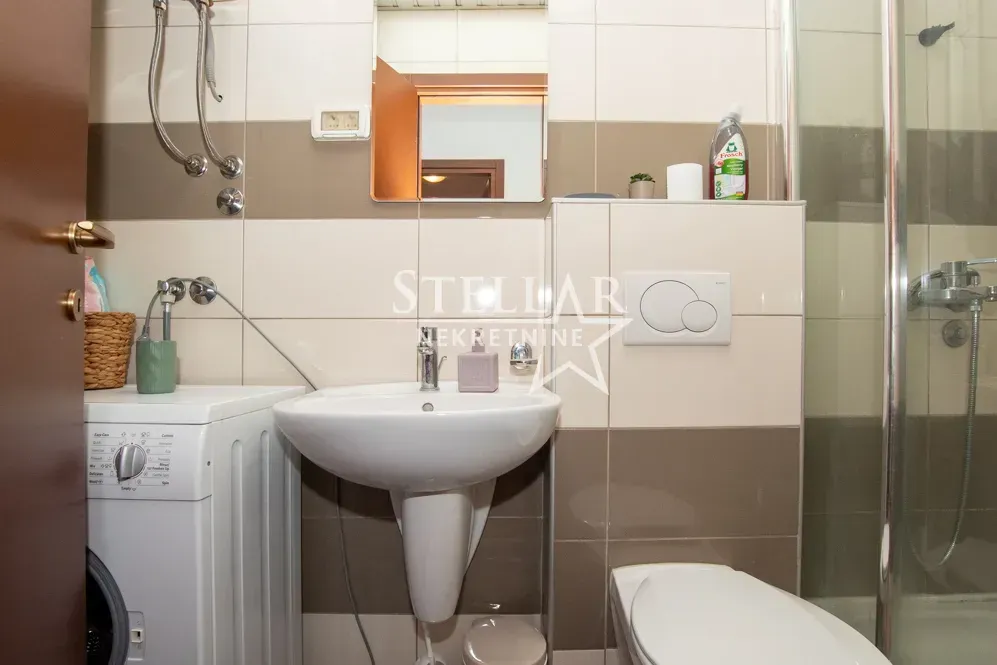 Bathroom equipped with a washbasin, toilet, shower cabin and washing machine.