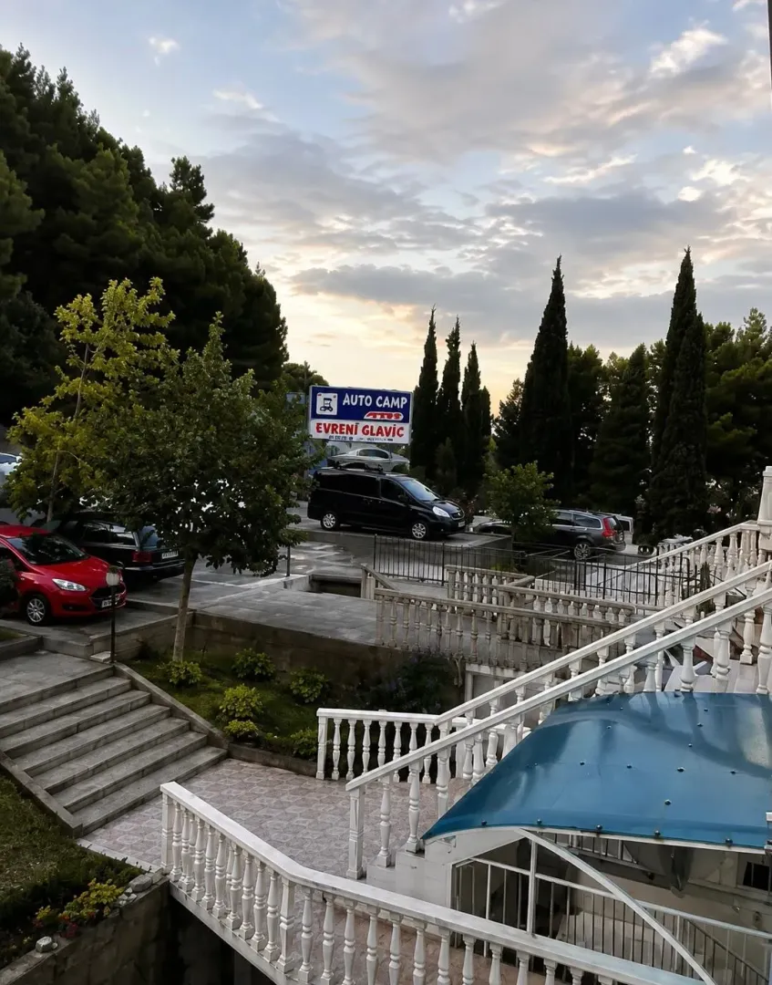 Eksterijer objekta sa stepeništem i uređenim dvorištem.