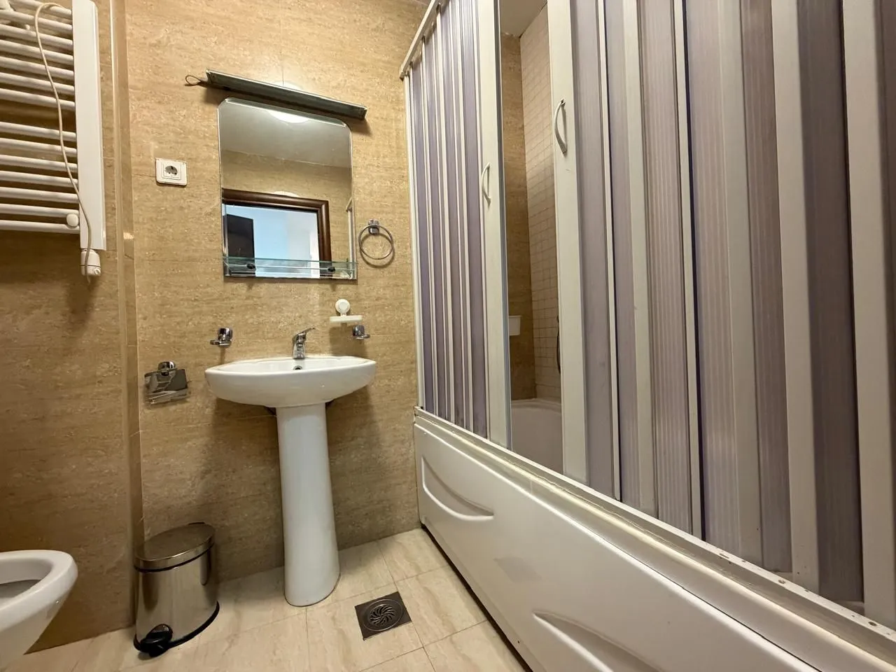 Smaller bathroom with a washbasin, mirror, and shower cabin.