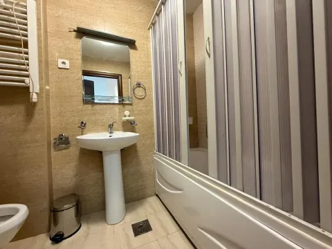 Smaller bathroom with a washbasin, mirror, and shower cabin. - image 13