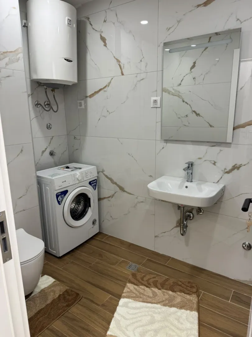 Modernly equipped bathroom with washing machine and water heater.