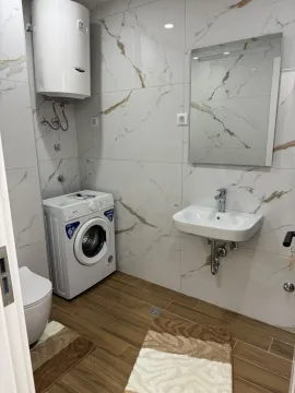 Modernly equipped bathroom with washing machine and water heater. - image 9