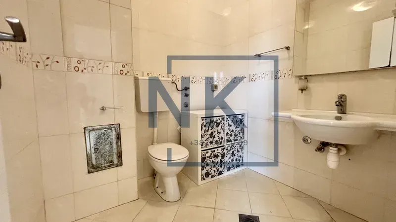 Bathroom equipped with sanitary fixtures, a sink, toilet, and wall tiles.