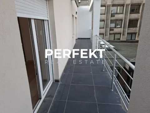 Dugačka popločana terasa sa metalnom ogradom i pogledom na grad. - image 5