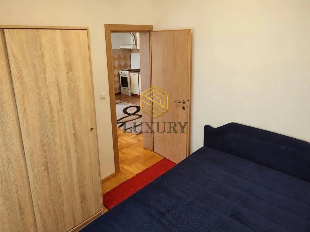 Furnished bedroom with a bed and wardrobe.