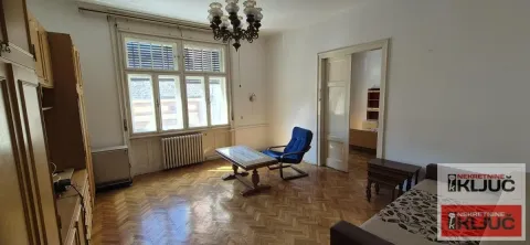 Dnevna soba sa drvenim parketom, nameštajem i velikim prozorima. - image 3