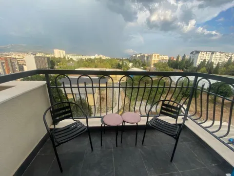 Namješten balkon sa garniturom za sjedenje i pogledom na grad. - image 6