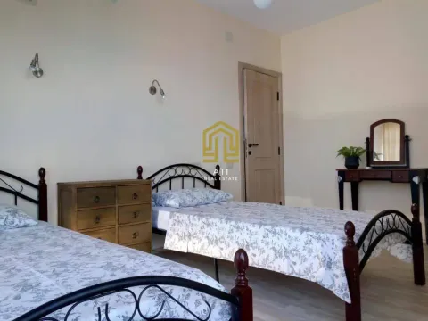 Bedroom with two beds, a chest of drawers, and a mirror. - image 6