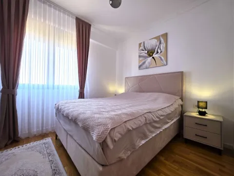 Uređena spavaća soba sa bračnim krevetom i prozorom sa zavjesama. - image 11