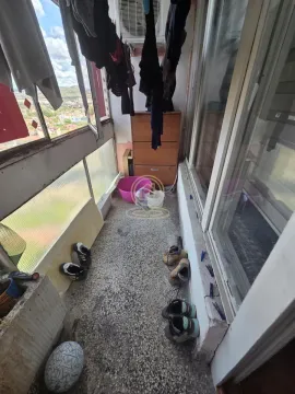 Enclosed balcony with shoes and laundry hanging to dry. - image 17