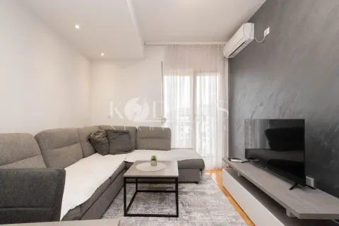 Living room with a sectional sofa, television, and air conditioning unit. - image 2