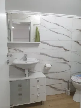 Manje kupatilo sa umivaonikom, ogledalom i belim keramičkim pločicama sa mermernom šarom. - image 9
