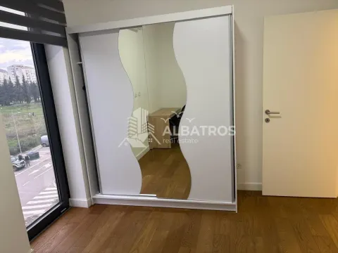 Spavaća soba sa velikim ugradnim garderoberom sa ogledalom i drvenim podom. - image 5