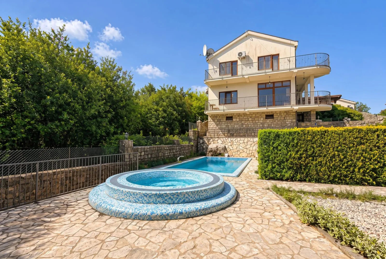 Exterior of the house with a swimming pool and jacuzzi in the yard.