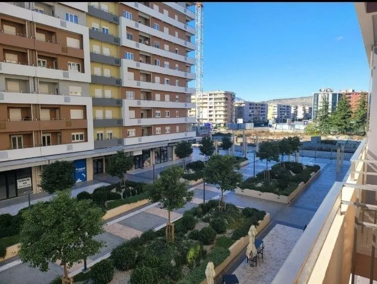 View from the balcony overlooking a landscaped courtyard and buildings.