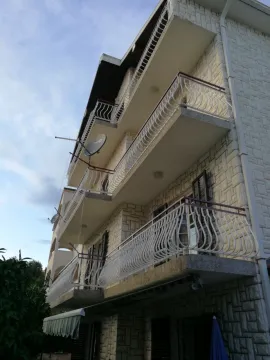 Vanjski izgled višespratne zgrade sa balkonima i kamenom fasadom. - image 7