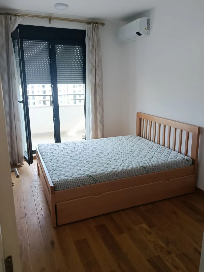 Bedroom with a wooden bed and access to the terrace.