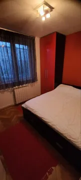 Spavaća soba sa bračnim krevetom, crvenim garderoberom i prozorom. - image 8