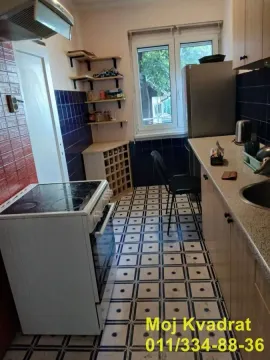 Small kitchen with a stove, refrigerator, sink, and open shelves. - image 4