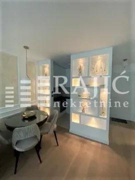 Living room with dining area and built-in decorative shelves. - image 2