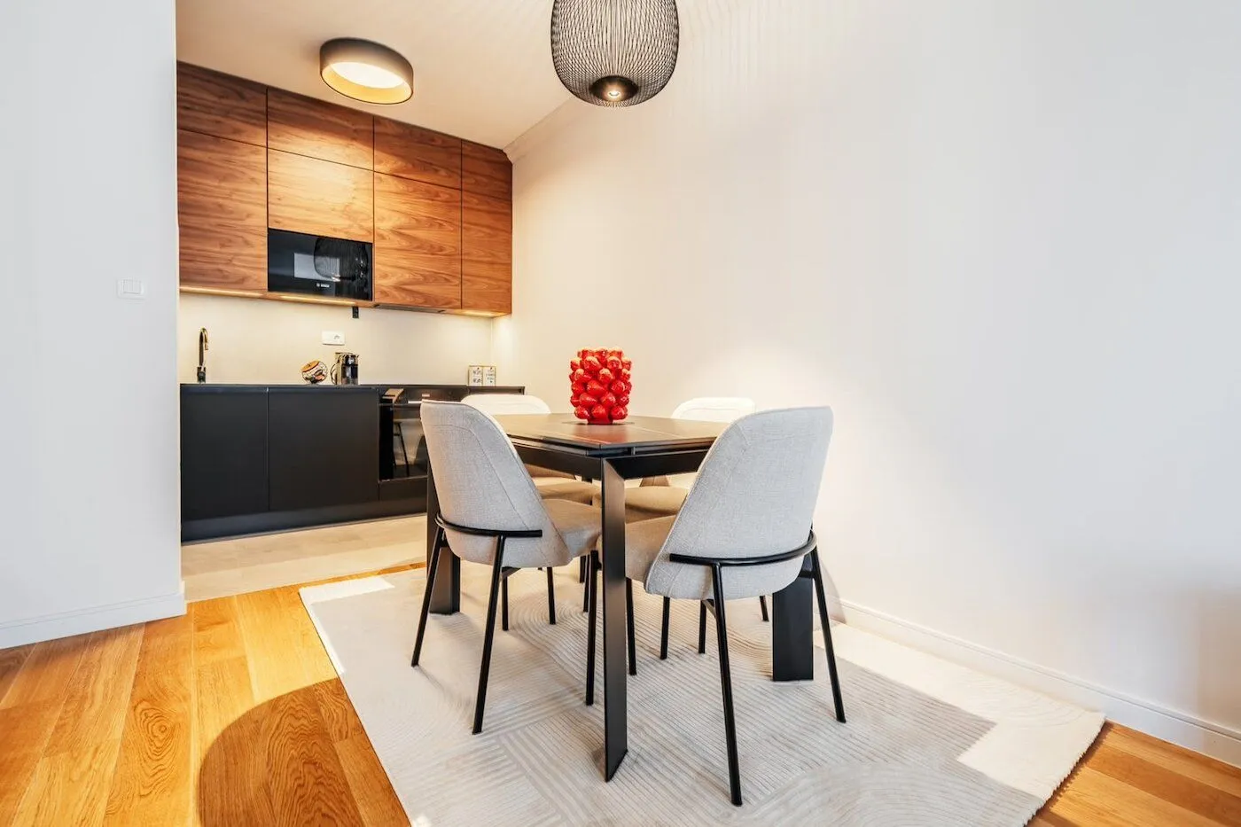 Modern kitchen with a dining area and built-in elements in dark tones.