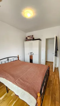 Bedroom with a double bed, white wardrobe, and wooden flooring. - image 6