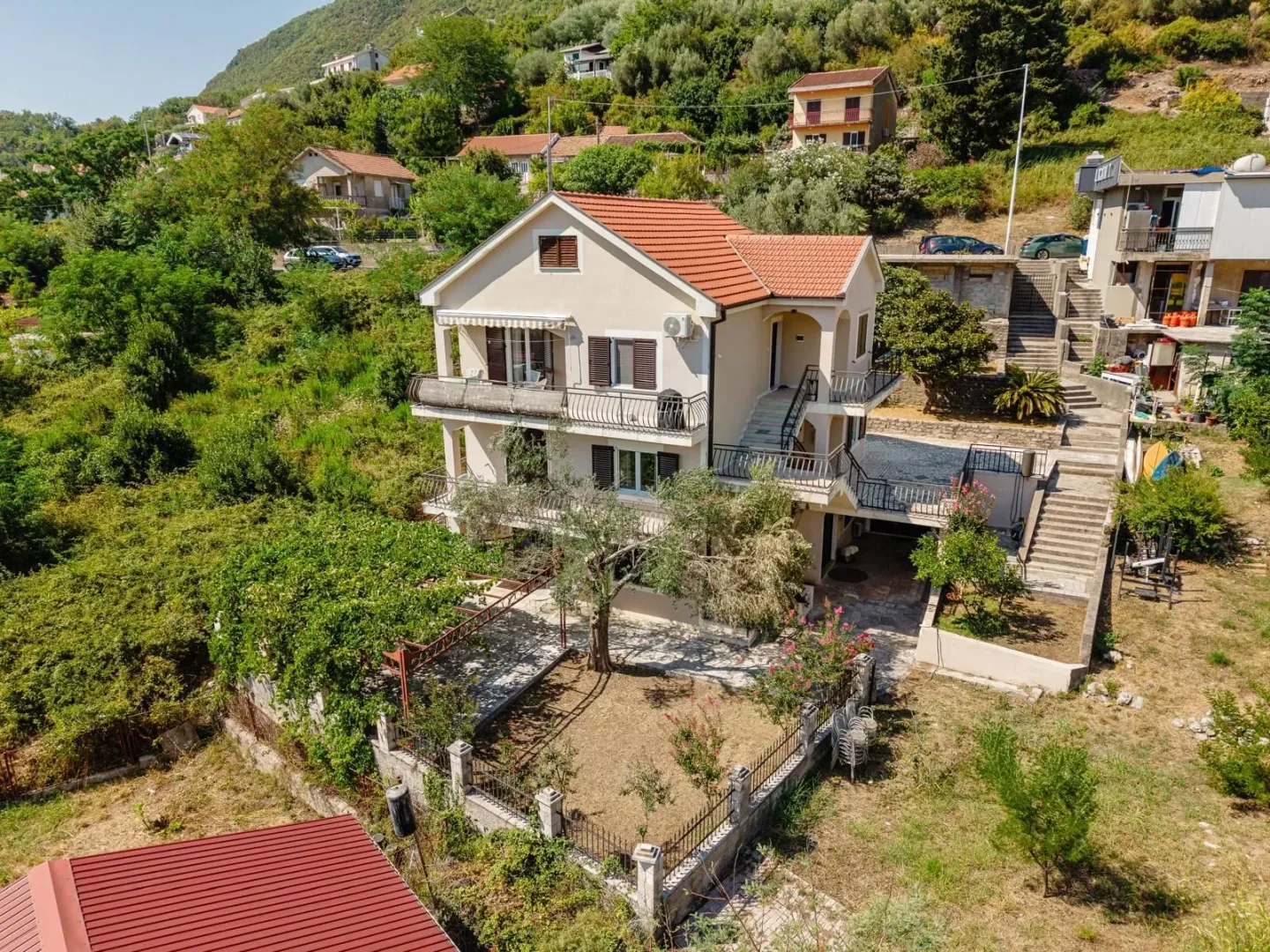Pogled iz vazduha na porodičnu kuću sa dvorištem i terasama.
