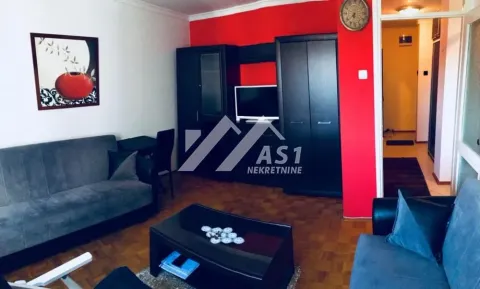 Dnevna soba sa garniturom za sedenje, televizorom i parketom na podu. - image 3
