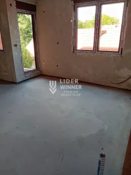 Unfinished room in grey phase construction with windows and concrete floor. - image 9