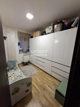 Dečja soba sa krevetom i velikim belim ormanom. - image 11