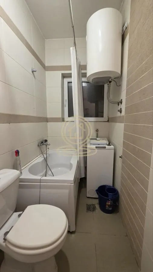Manje kupatilo sa kadom, wc šoljom, veš mašinom i bojlerom.