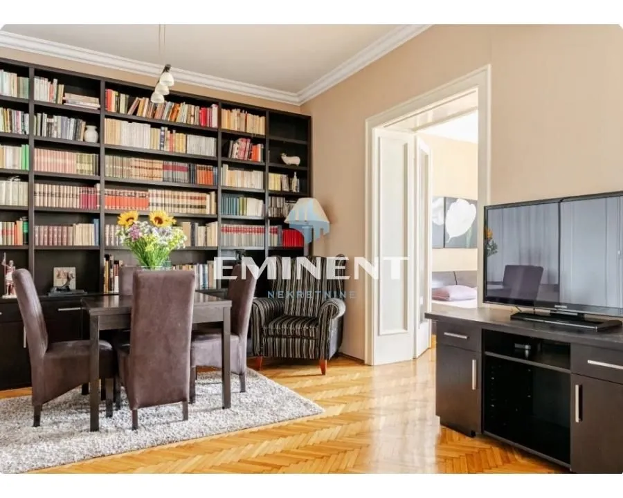 Living room with a large bookcase, dining table, and television.